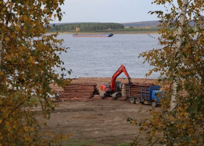 a crane is working on a pile of logs